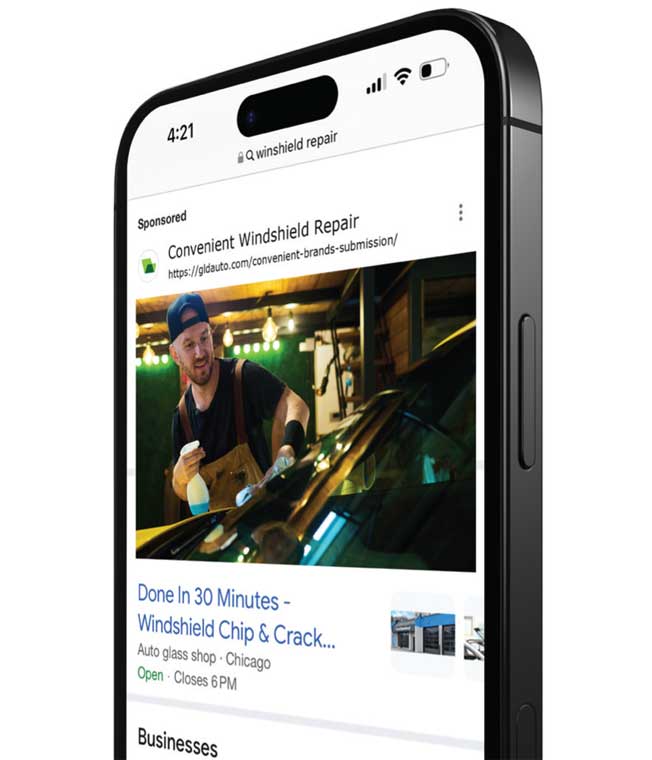 A mobile device with a digital ad for windshield repair on screen